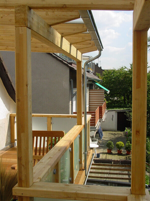 Überdachter Balkon mit hellen Holzstützen